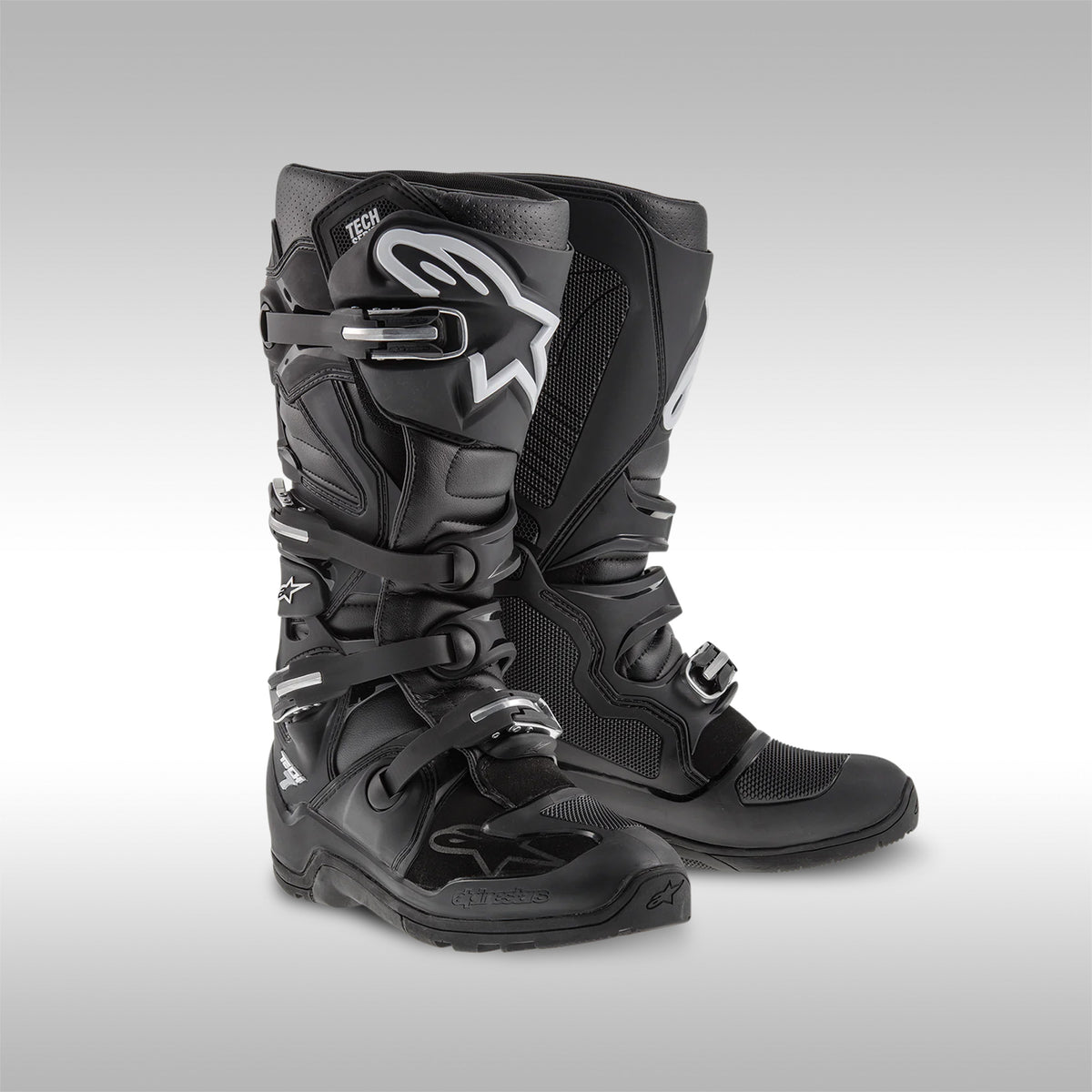 Alpinestars Tech 7 Enduro boots in the all Black with White logos option. The left and right boot next to each other. Enduro and dualsport motorcycle boots. Protective gear for dirtbike riding.