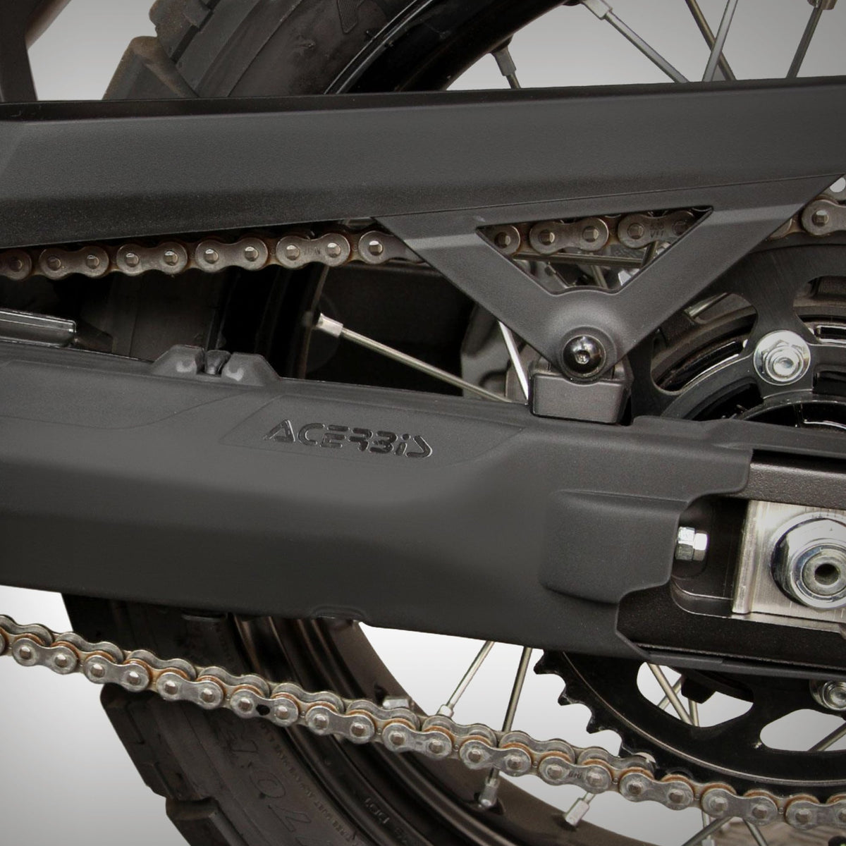 Two black Yamaha Ténéré 700 swing arm guards on a gray background