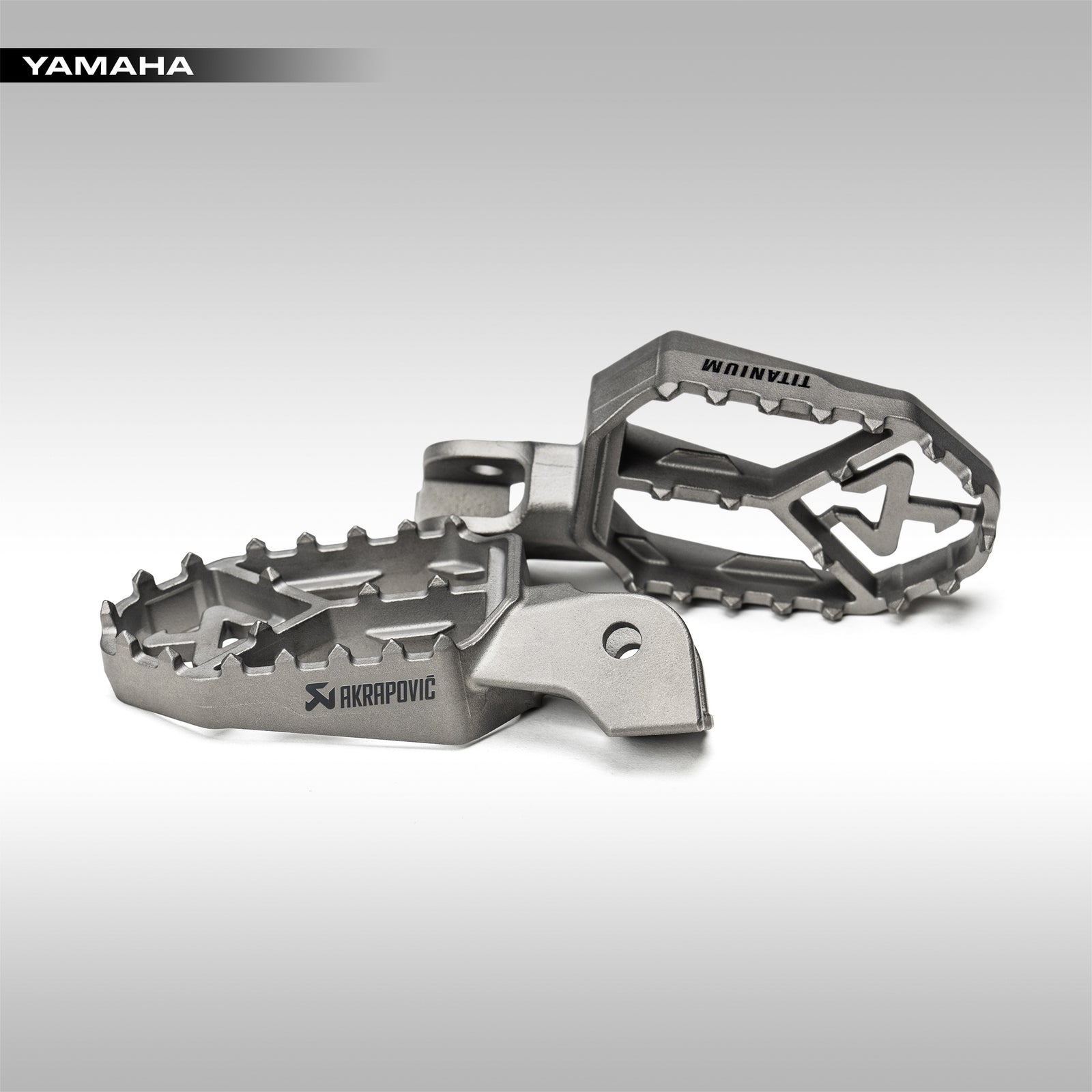 Akrapovic titanium footpegs for Yamaha Tenere 700 on a gray background
