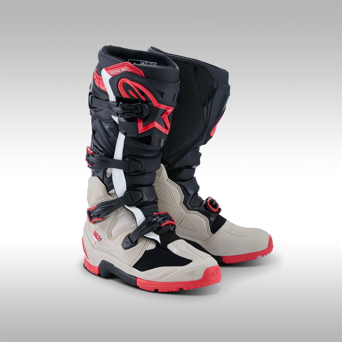 Pair of black, gray and red Alpinestars Tech 7 Enduro offroad boots on a gray background at TMBR MOTO