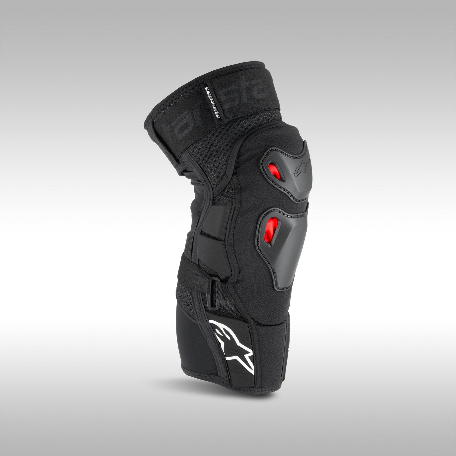 Alpinestars Bionic Pro Plasma Knee Protector, black with red accents, designed for off-road motorcycle riding, featuring straps and protective padding.