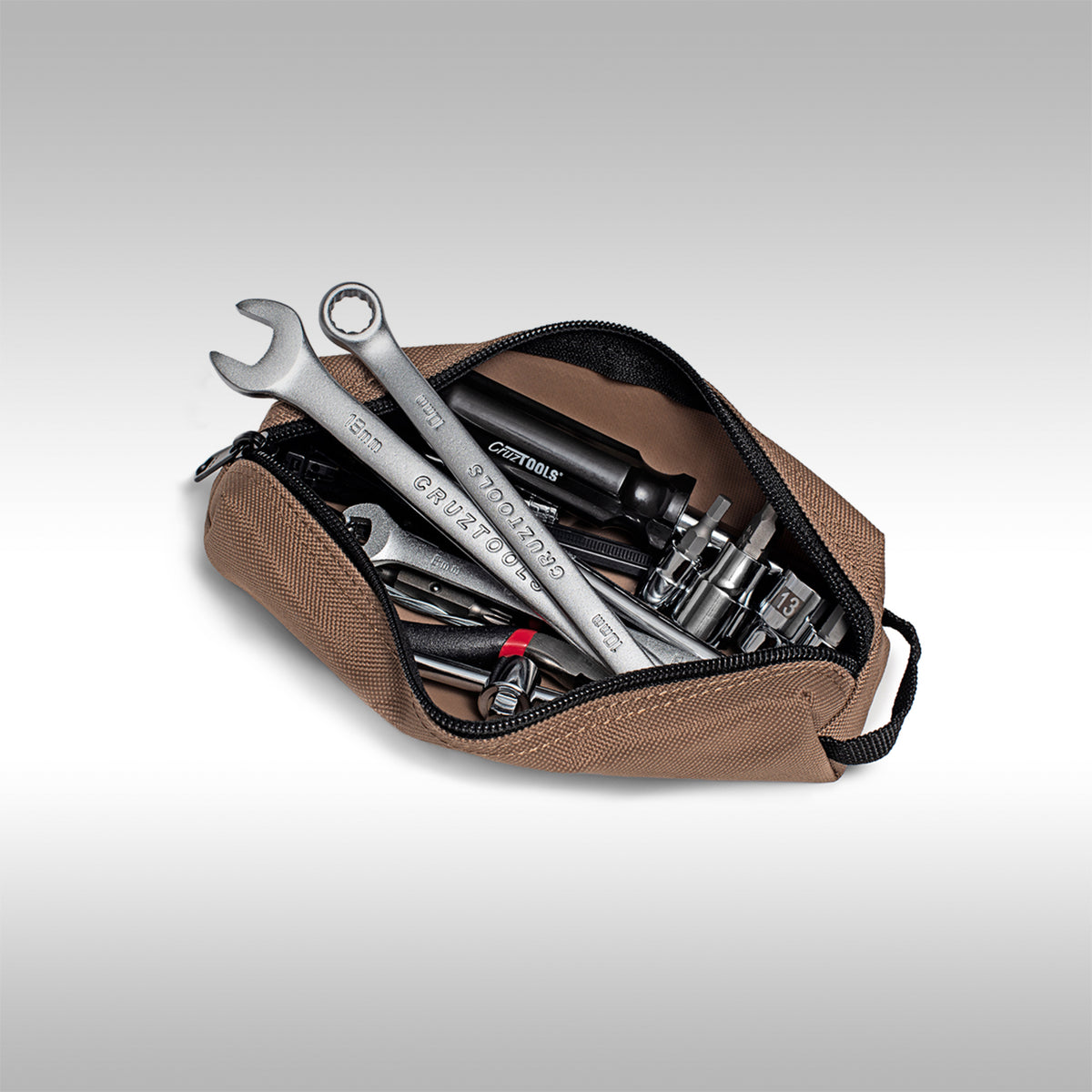 Brown tool pouch with various CruzTools dirtbike tools on a light gray background