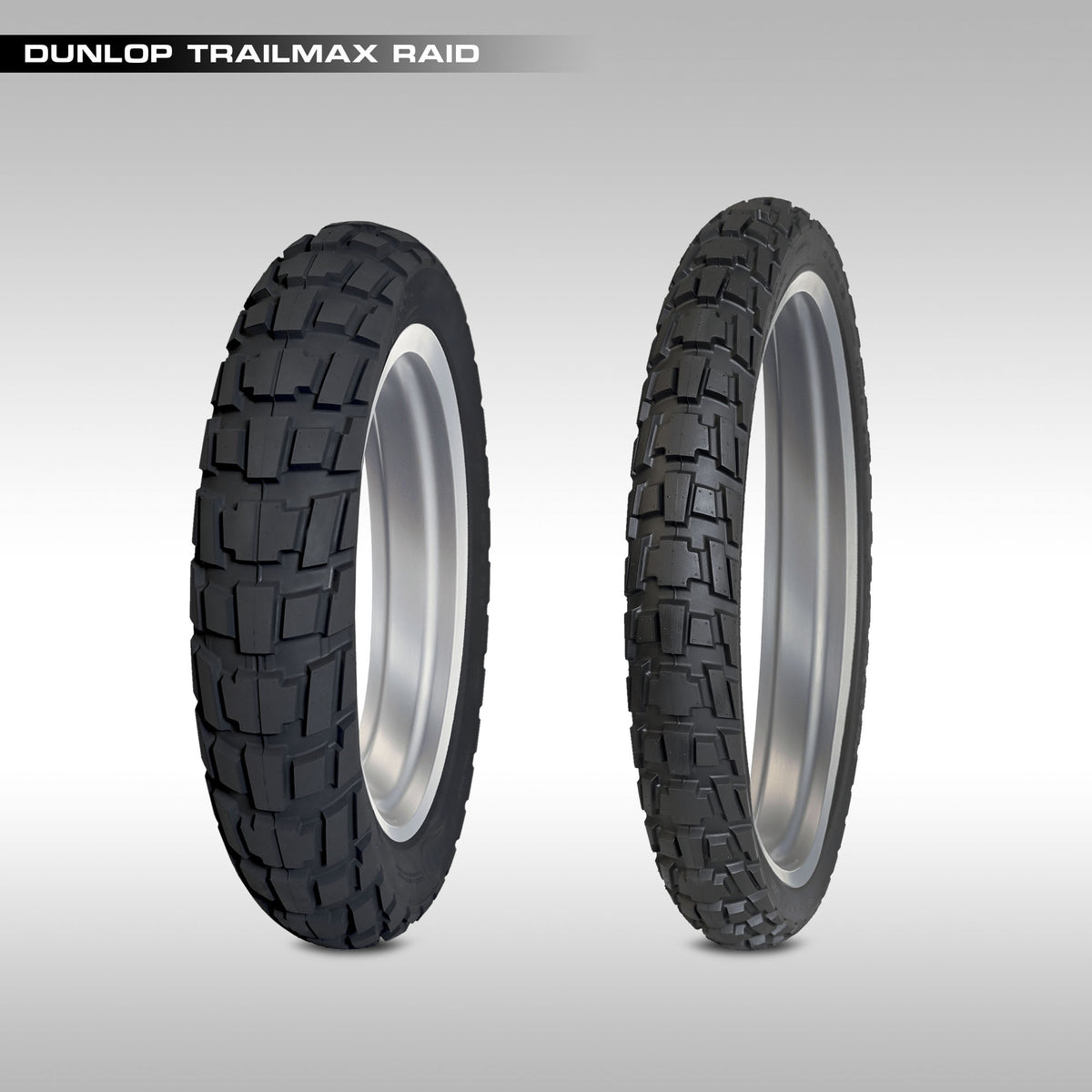 Two Dunlop Trailmax Raid tires on a gray background
