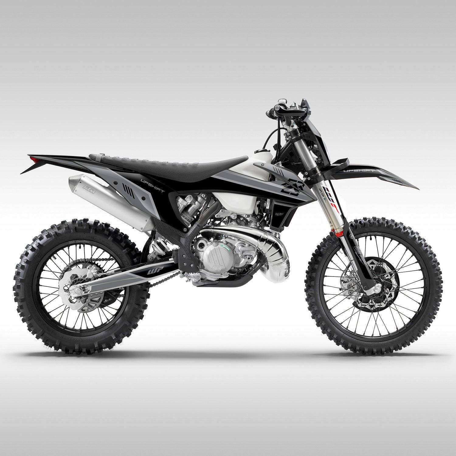 A KTM motorcycle with the gray baseline graphics kit applied, showing a matte finish on the body panels, wheels, and other motorcycle parts.