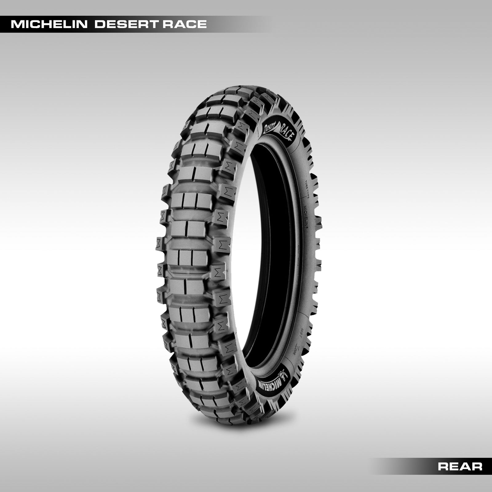 Michelin desert race motorcycle tire, black with off-road tread pattern, labeled 'Michelin Desert Race' and 'REAR'.