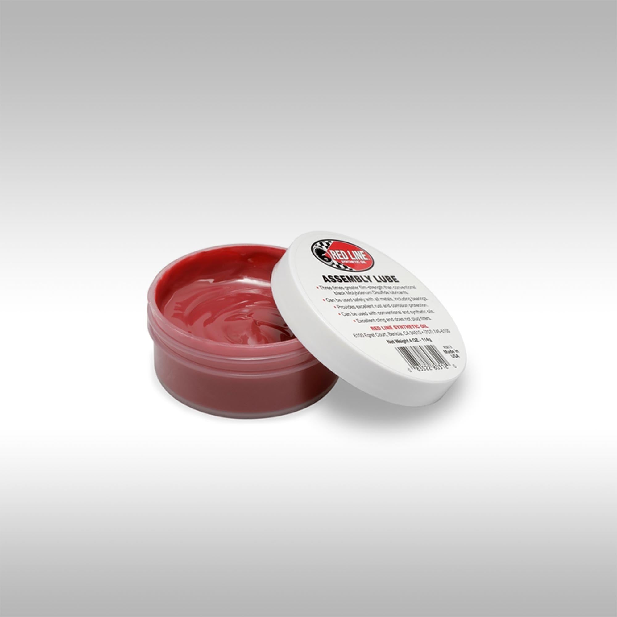 Red Line assembly lube container with white lid on a gray background