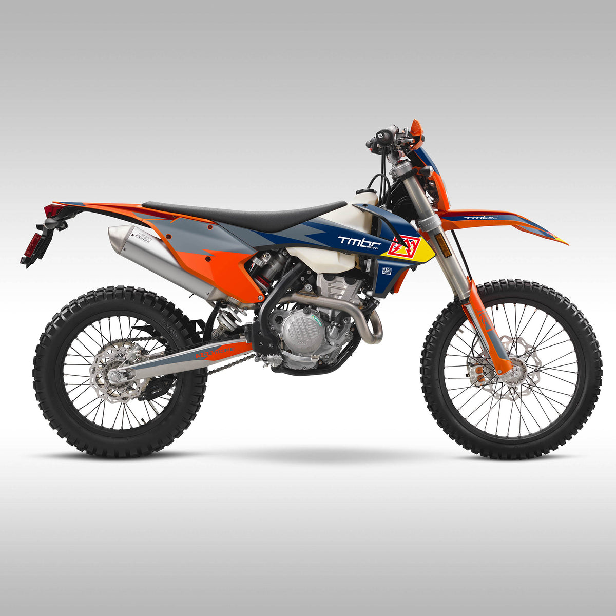 Orange, blue, gray and black dirt bike on a gray background