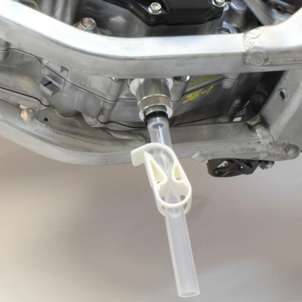 Works Connection 24-100 EZ Oil Drain tool featuring an aluminum adapter, silicone hose, and flow clamp.