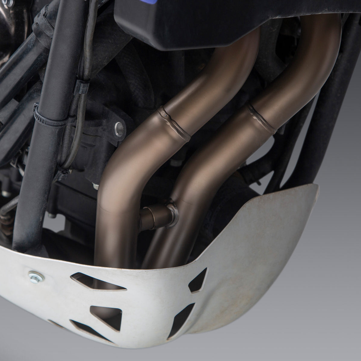 Close-up of a motorcycle exhaust system on a gray background