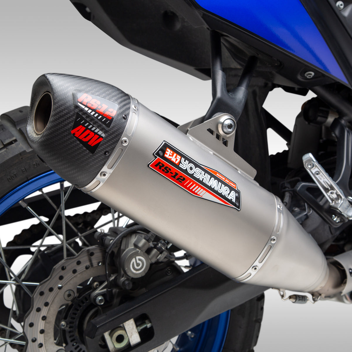 Close-up of a motorcycle exhaust system with Yoshimura branding on a gray background