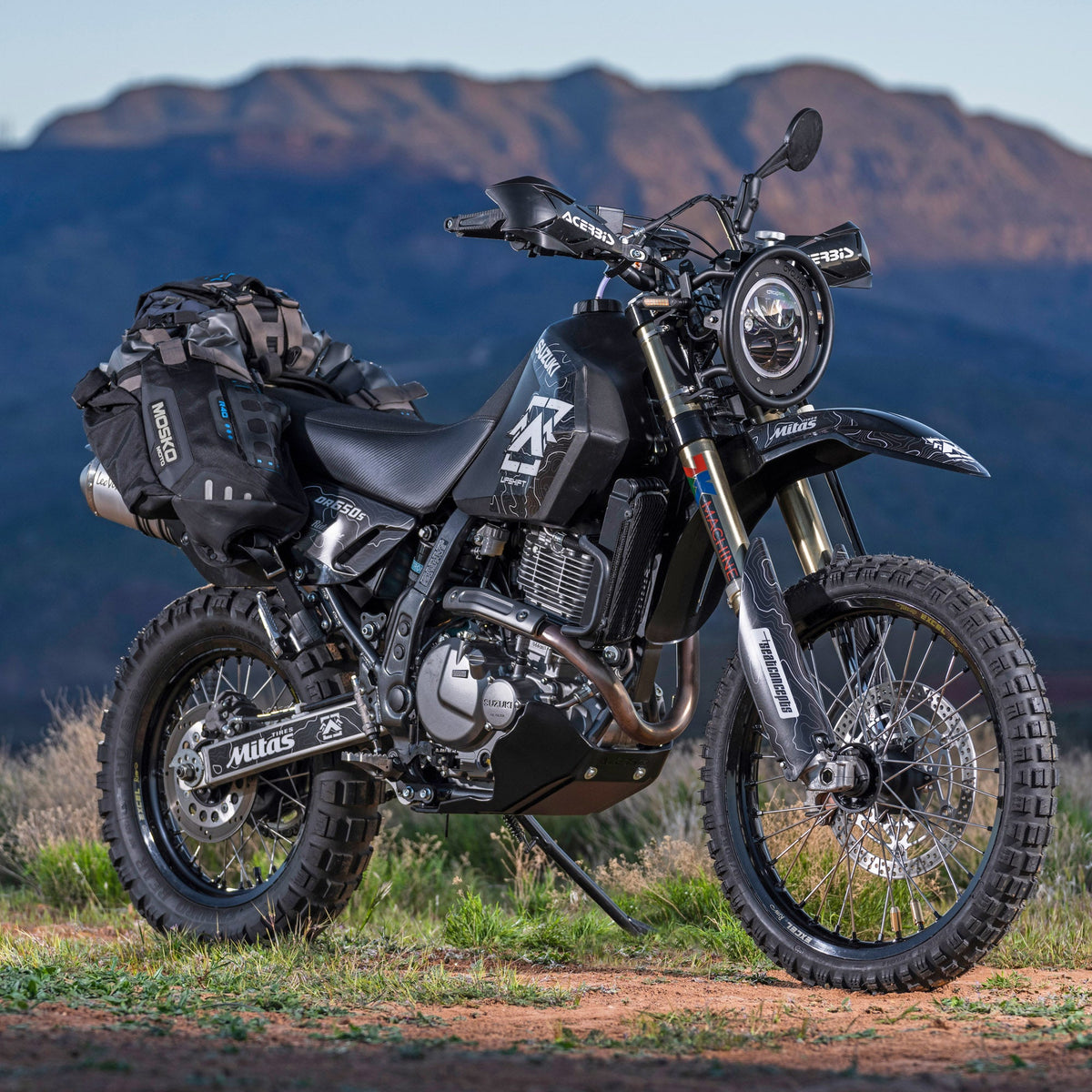 Upshift Online's 2022 DR650 project bike in the mountains.  Shown with accessories from TMBR MOTO like the Acerbis skid plate, Doubletake Mirrors, Seat Concepts seat and of course and Acerbis 5.3 gallon fuel tank.