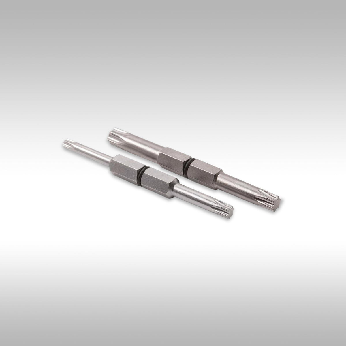 Two metallic TORX bits on a light gray background